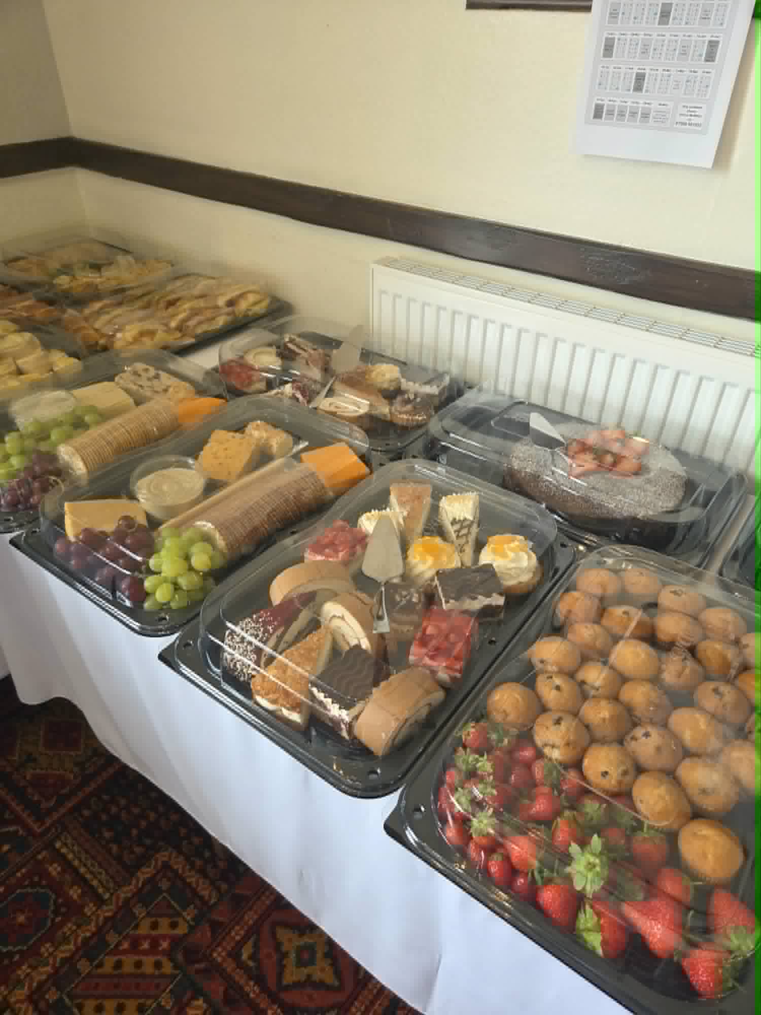 Cheese boards, cakes, muffins and strawberries on a buffet table