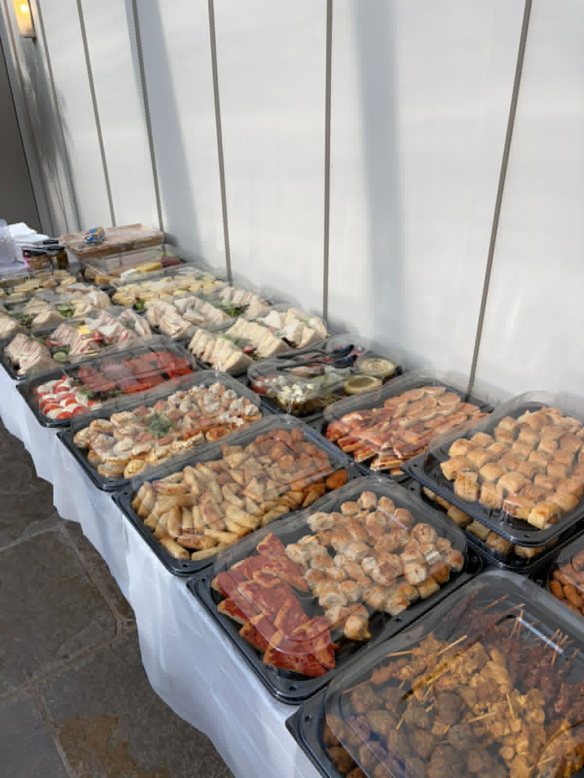 Finger buffet spread with sausage rolls, wraps and skewers